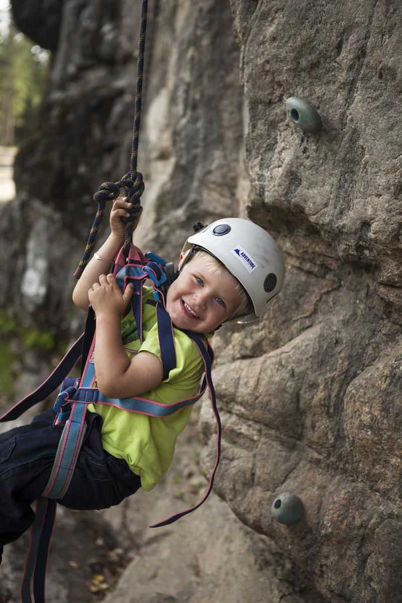 Young smiling boy climbing and rapelling
