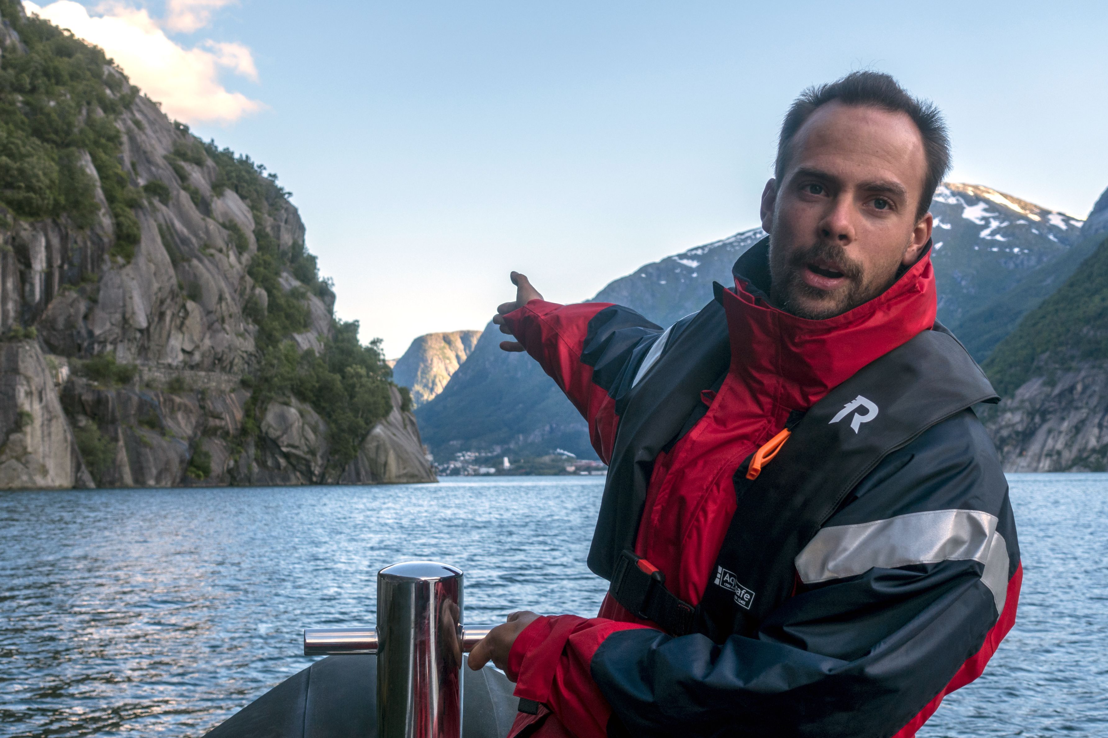 Lokal guide peikar ut naturskjønne attraksjonar under RIB-safarien i Hardanger.