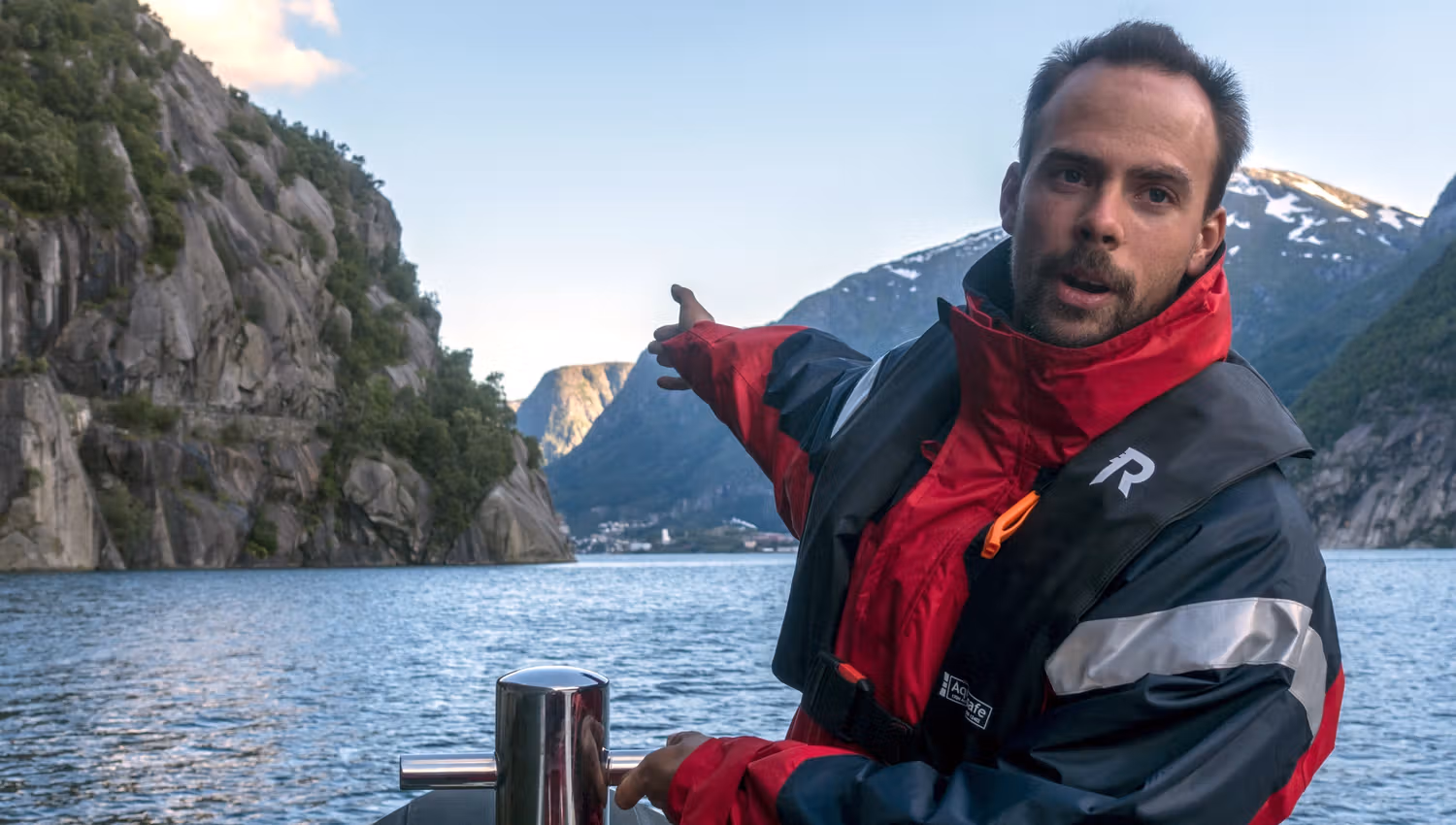 Lokal guide peikar ut naturskjønne attraksjonar under RIB-safarien i Hardanger.