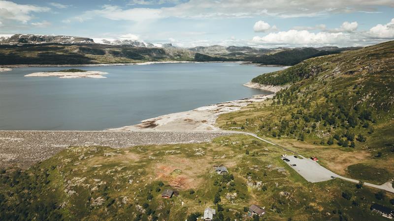 A drone photo showing the parking lot in the front and the dam in the background.