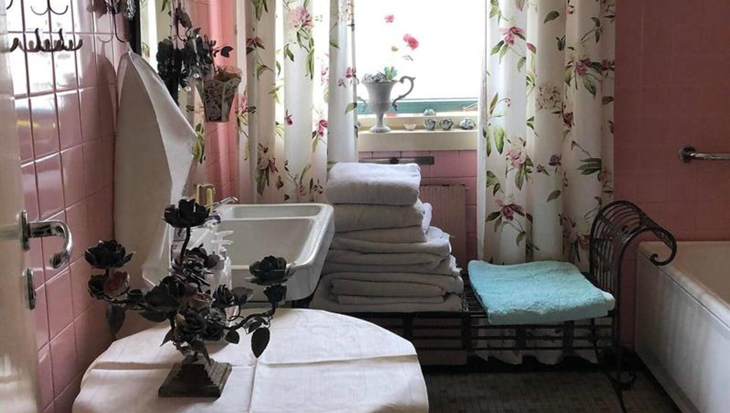 Flislagt rosa bad med håndduker