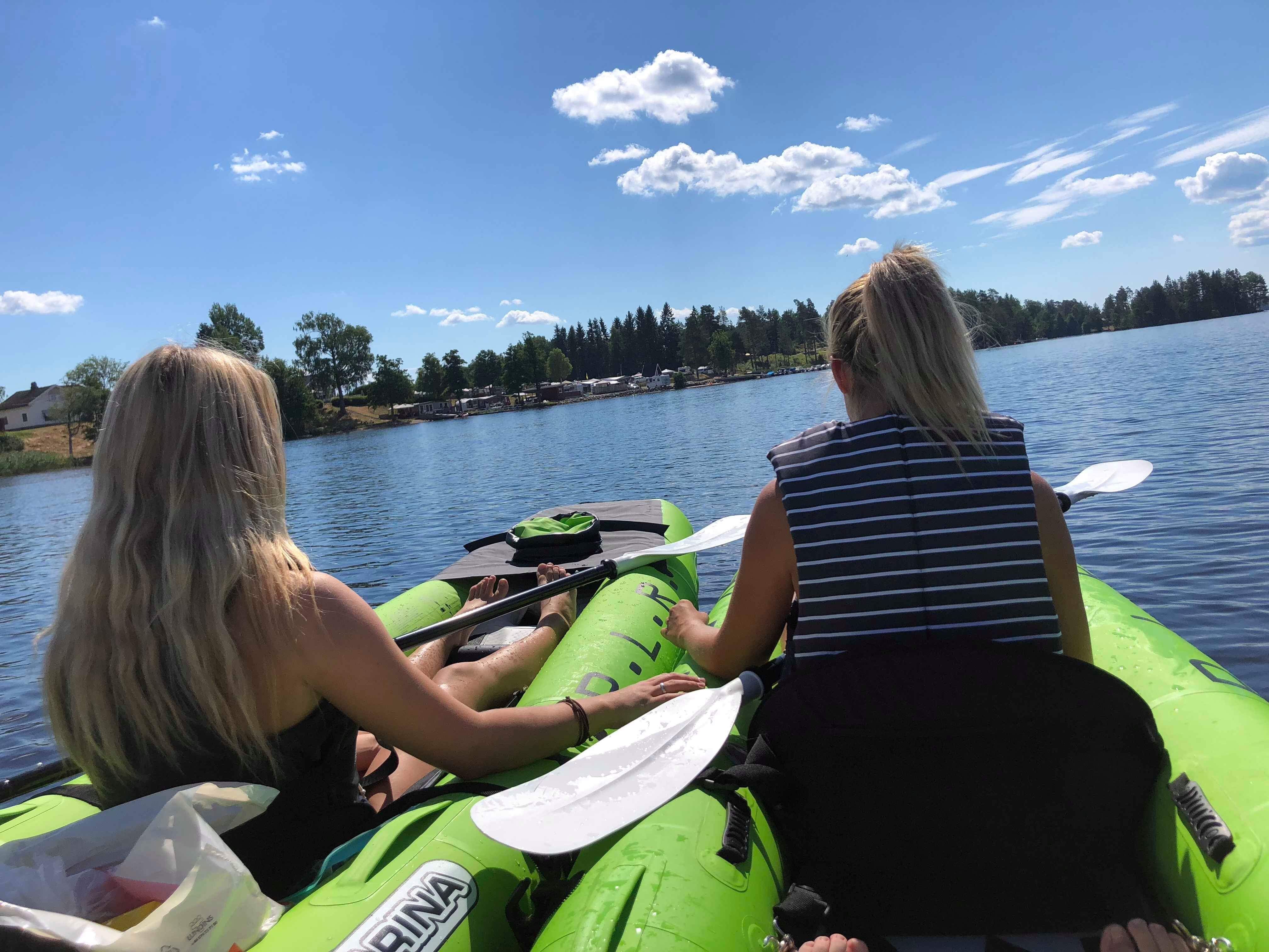To jenter i to kajakker på vannet