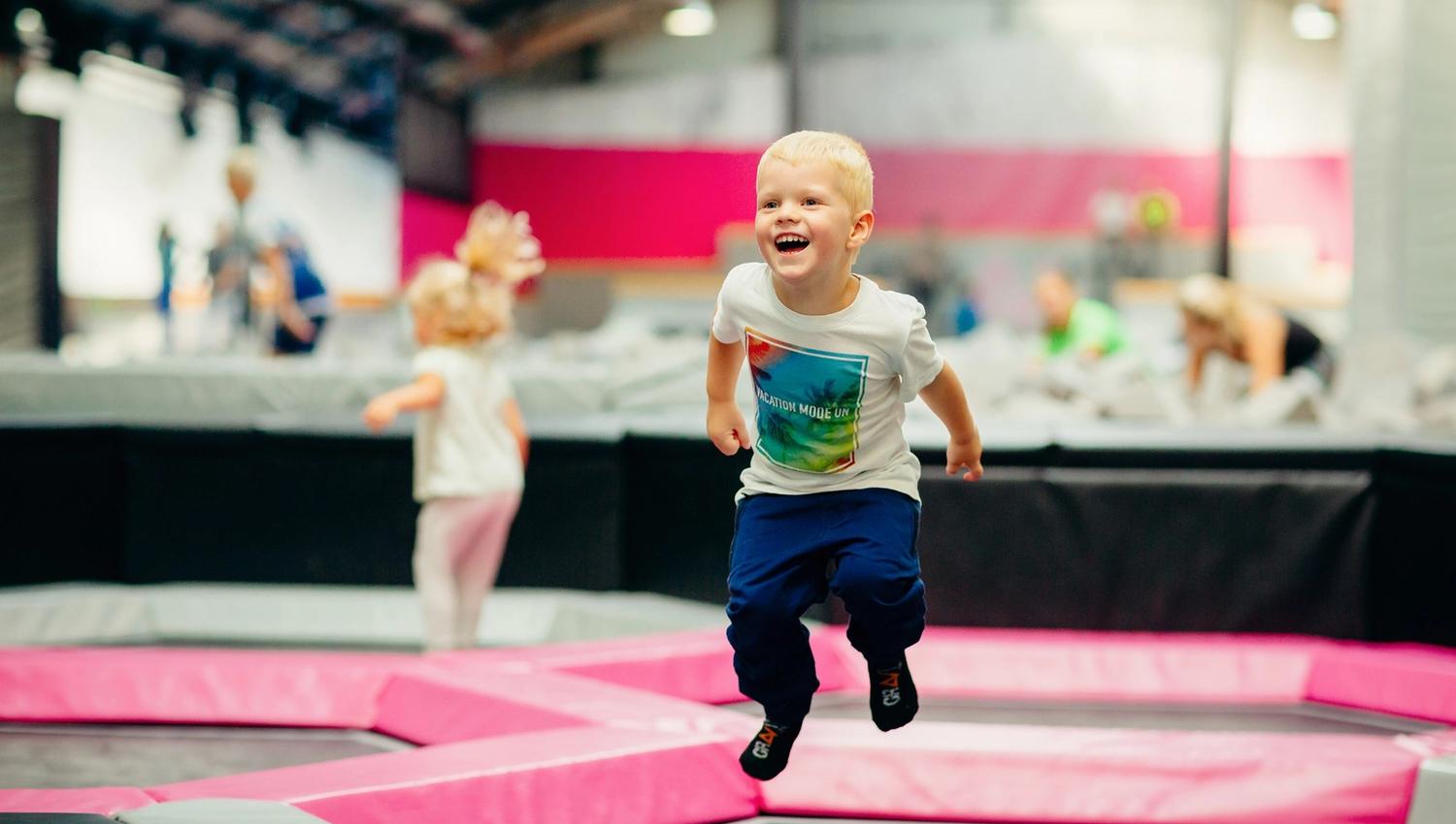 En liten gutt hopper på trampoline