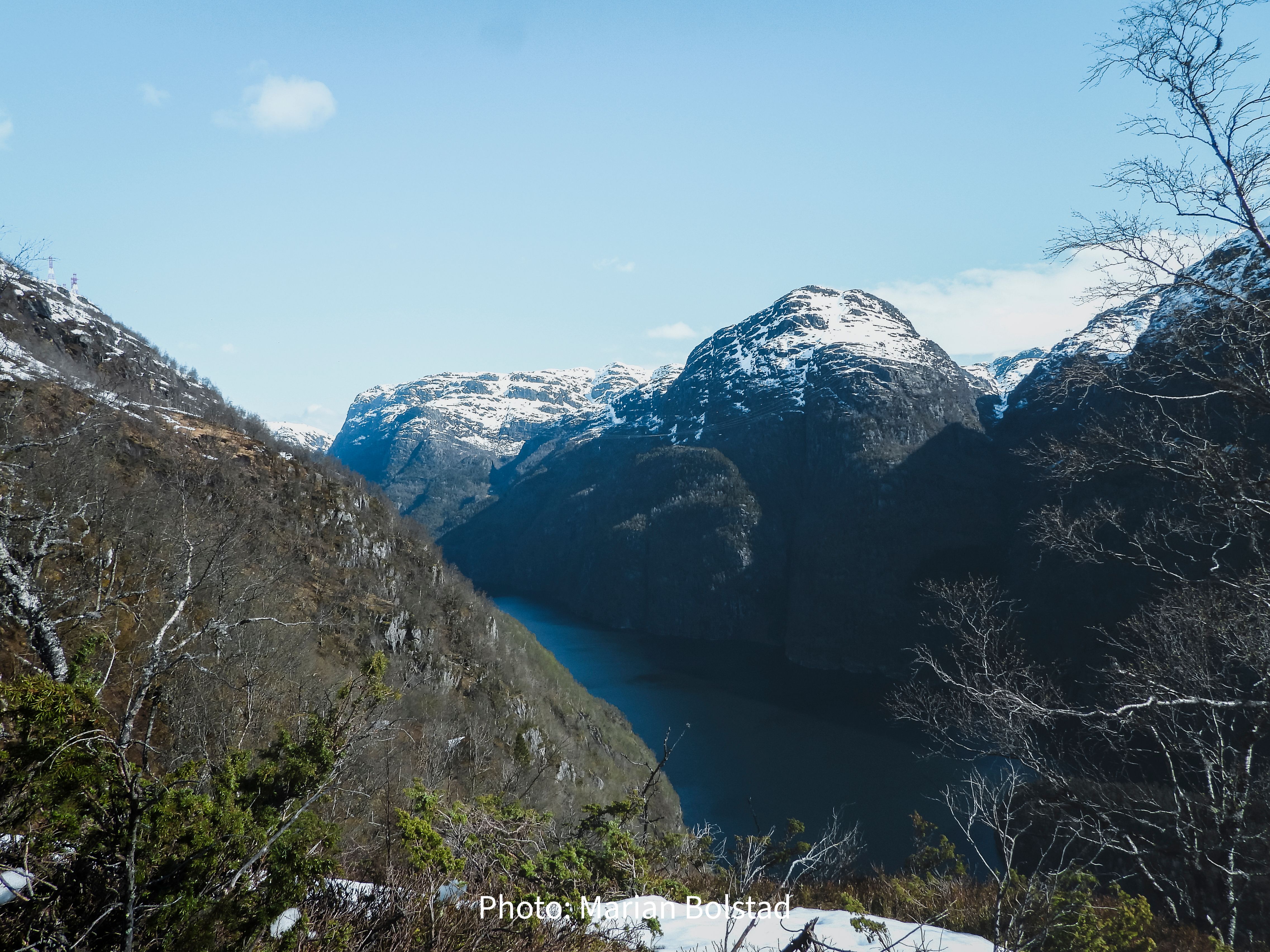 Deep fjord surrounded by snow-capped mountains in Hardanger, Norway, showcasing dramatic fjord scenery