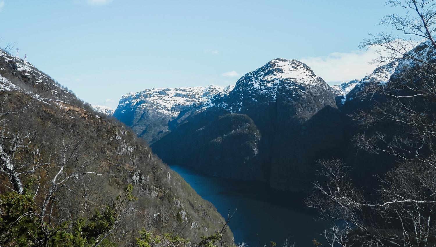 Deep fjord surrounded by snow-capped mountains in Hardanger, Norway, showcasing dramatic fjord scenery