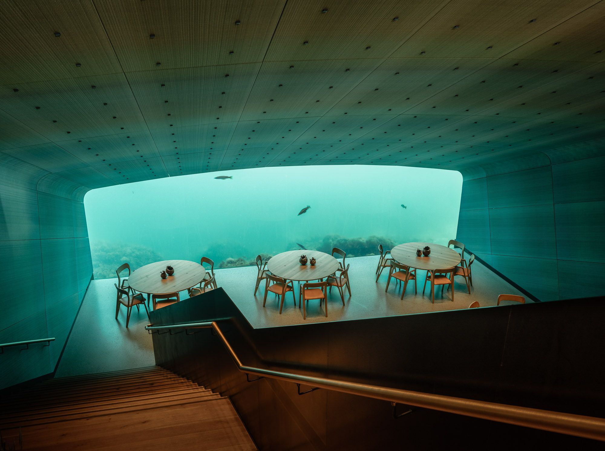 Tische und Stühle mit Blick unter das Meer, im Restaurant Under.
