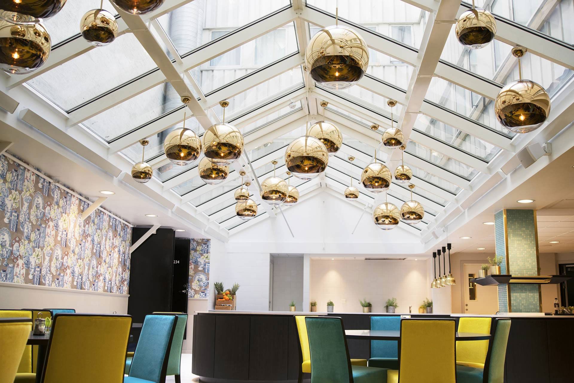 Lobby på Thon Hotel Terminus. Sittegrupper i blått og gult. Gylne taklamper. Foto