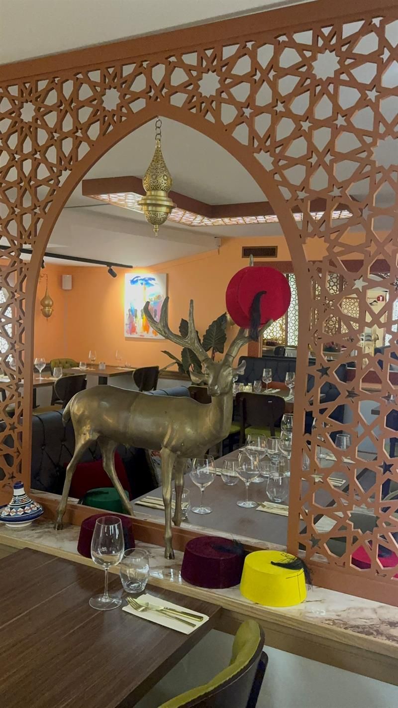 Utskårne trepaneler og en gullfarget hjort står midt i restaurantlokalet.
