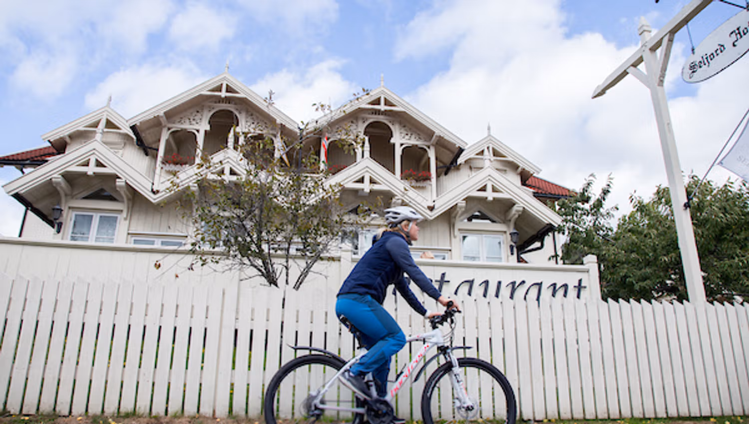 A cyclist rides past a house in Seljord.