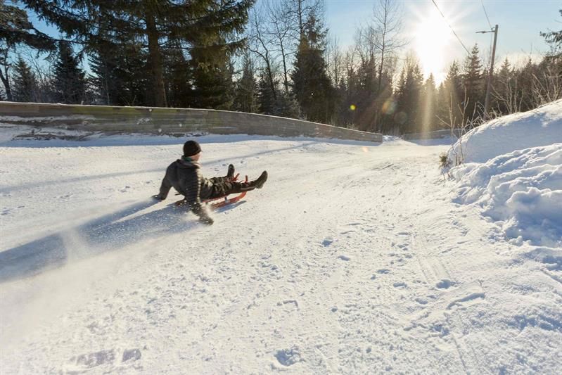 A person sledding down a snow-covered hill.