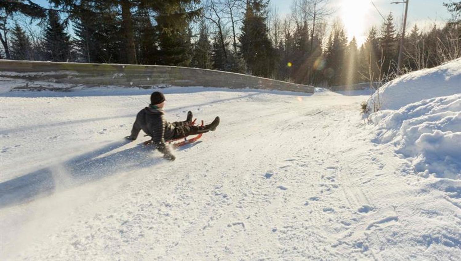 A person sledding down a snow-covered hill.