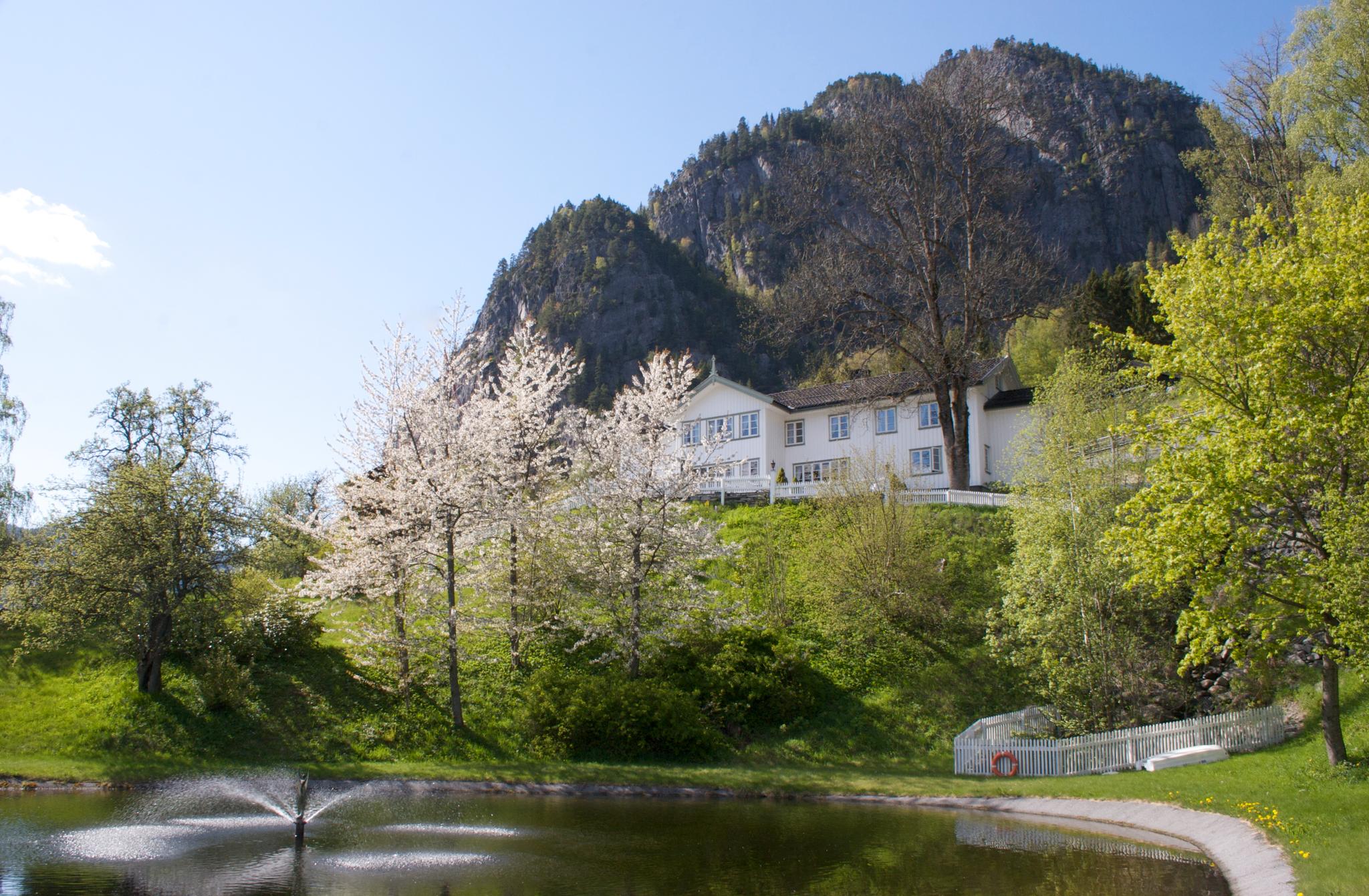 Nutheim Gjestgiveri er eit lite familiedrive trehotell i hjartet av Telemark med lang tradisjon 

for å ta imot vegfarande til servering og overnatting. Staden har vore i familiens eige sidan 

1917, og hotellet drivast no av Ellen Grøstad Barstad og hennar familie.


Kunsten står i høgsetet hjå oss. 

Det var hit til Nutheim mange av våre fremste målarar kom for inspirasjon gjennom fleire tiår. 

Her tok dei for seg av ro, lys, luft og motiv - men også av mat, drikke og gjestfridomen. 

Den fjerne utsikta over dalar og fjell inspirerer like mykje til sjelefred som til nye djerve tankar. 

Saman med fellesskapet forløyste desse rammene skapande krefter som har sett djupe spor i 

norsk kunsthistorie.


Nutheim er den dag i dag ein arena for kunst og kultur. 

Med jamne mellomrom held me arrangement i form av til dømes utstillingar og konsertar, 

og dersom kursgjester eller andre har ynskje om kulturinnslag kan me ty til eit breitt utval 

av dyktige kunstnara