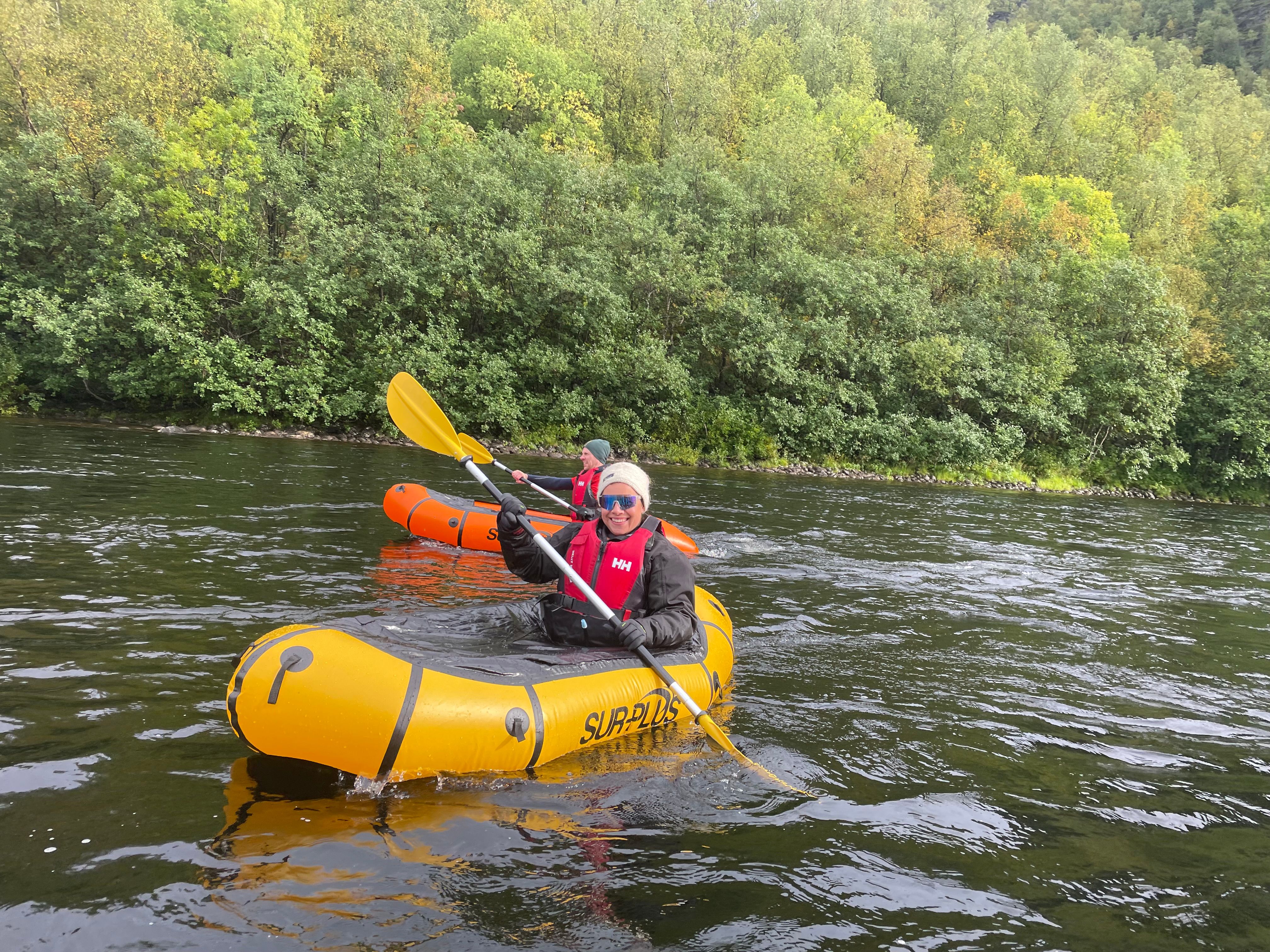 Deux personnes en kayak sur une rivière entourée d'arbres verdoyants.