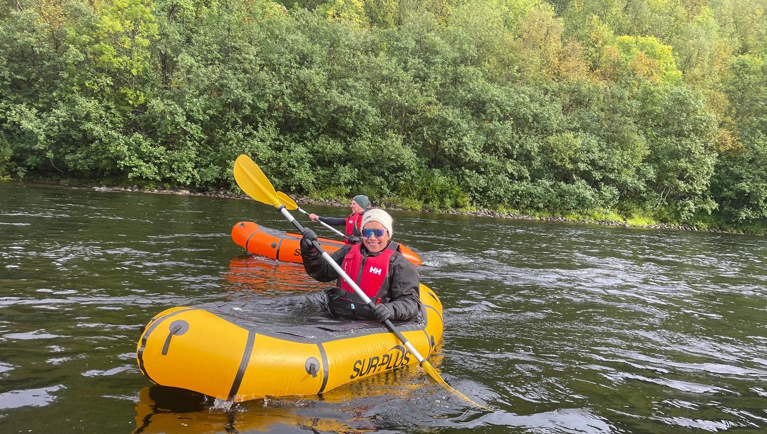 Deux personnes en kayak sur une rivière entourée d'arbres verdoyants.