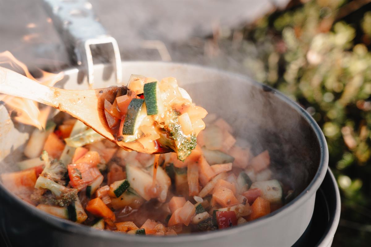 Pot with hot stew cooking over a fire