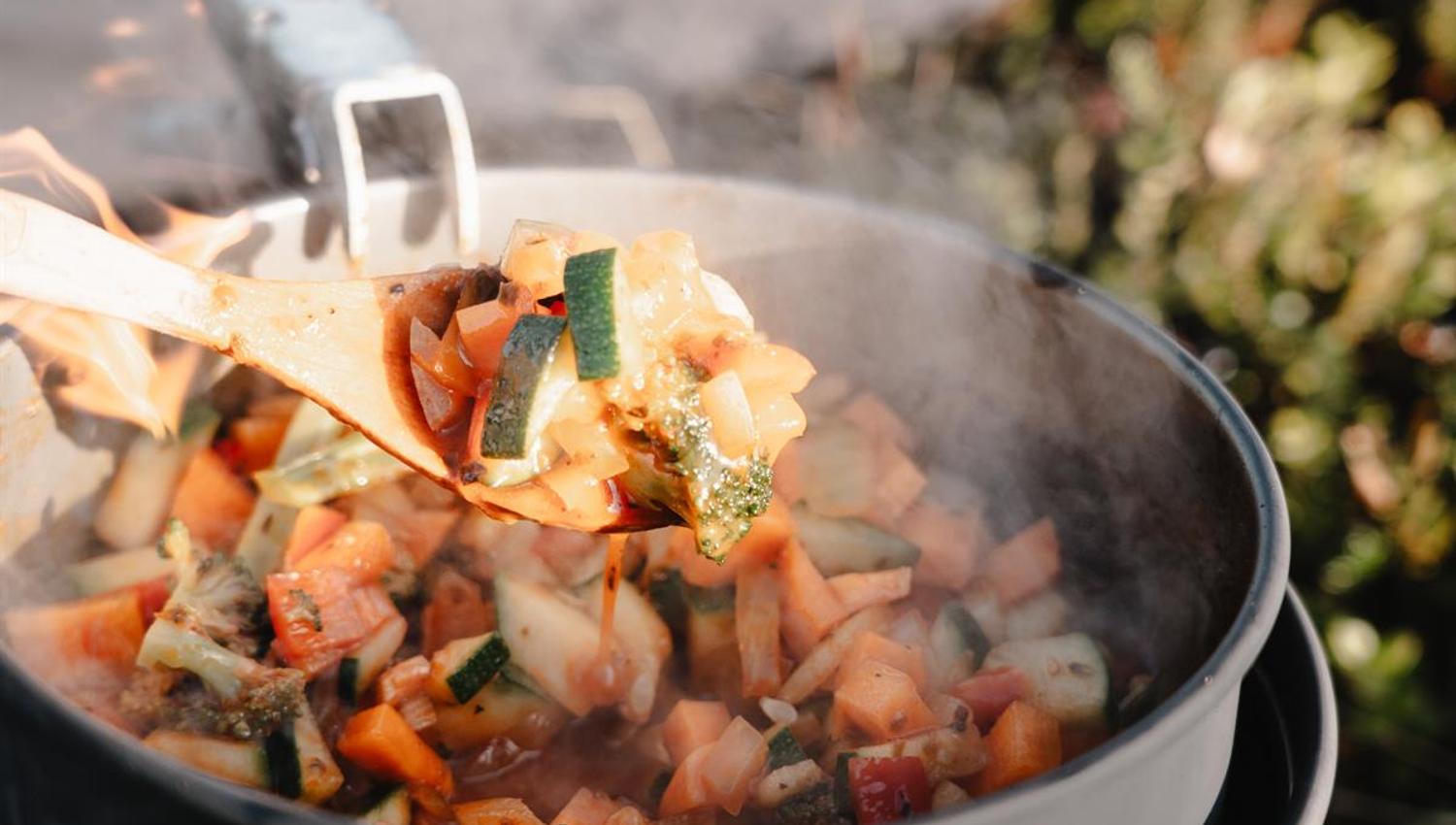 Pot with hot stew cooking over a fire