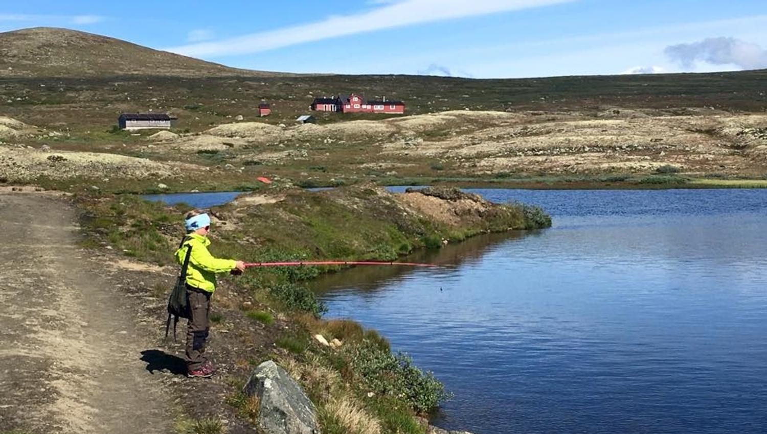En jente fisker i vatnet nedenfor Stigstuv fjellstue.