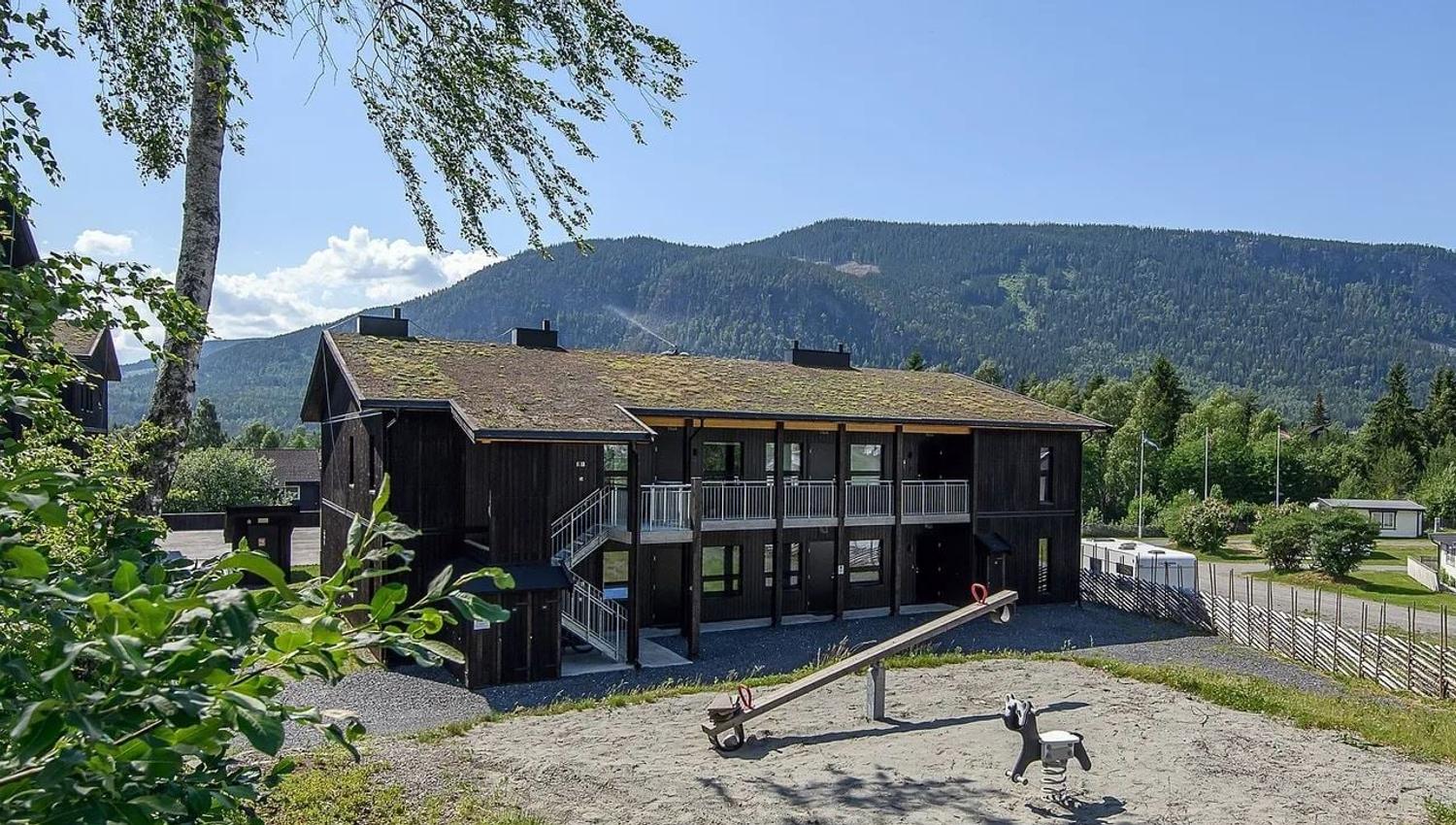 Ein Gebäude mit einem Spielplatz davor.