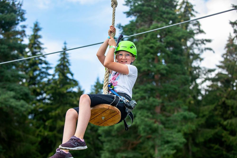 jente kjører zipline i klatreparken i Skien fritidspark
