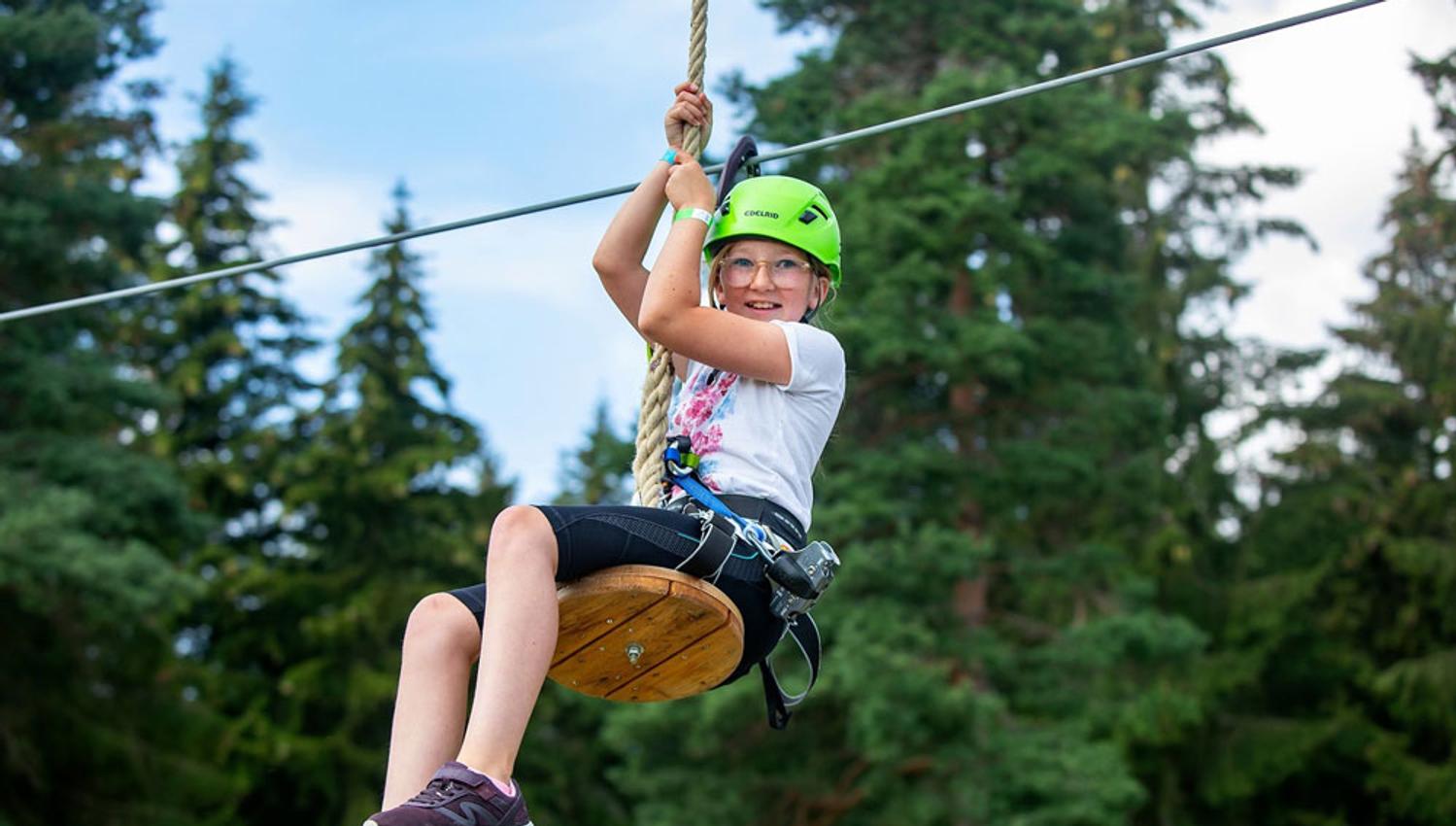 jente kjører zipline i klatreparken i Skien fritidspark