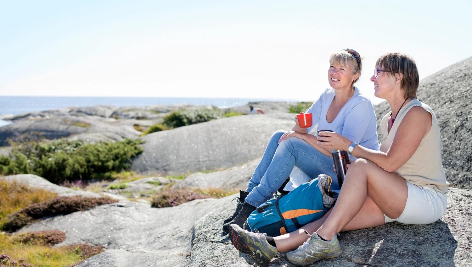 To som sitter og tar en kaffepause på kyststien