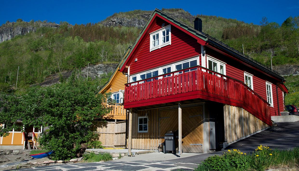 Red holiday house by the fjord in Hardanger, surrounded by nature and ideal for relaxing days by the water.