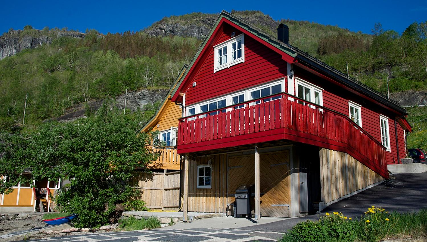 Red holiday house by the fjord in Hardanger, surrounded by nature and ideal for relaxing days by the water.