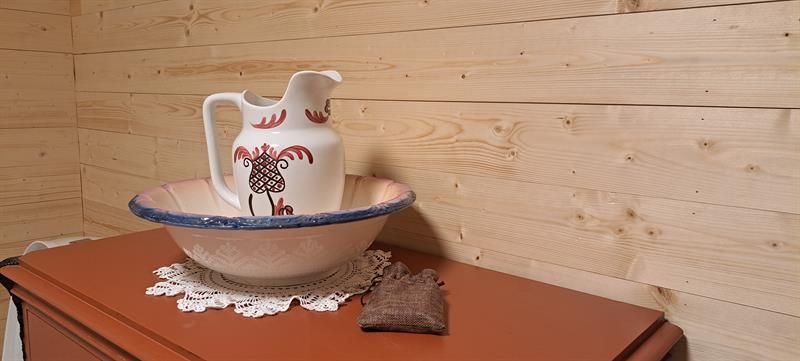 Interior detail in Gjeterhytta featuring a decorative wash basin and pitcher on a wooden cabinet