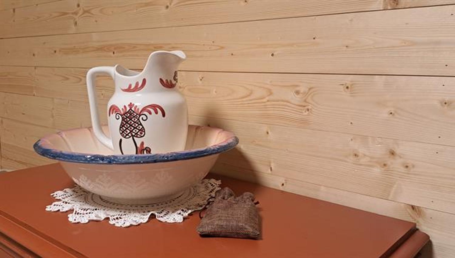 Interior detail in Gjeterhytta featuring a decorative wash basin and pitcher on a wooden cabinet