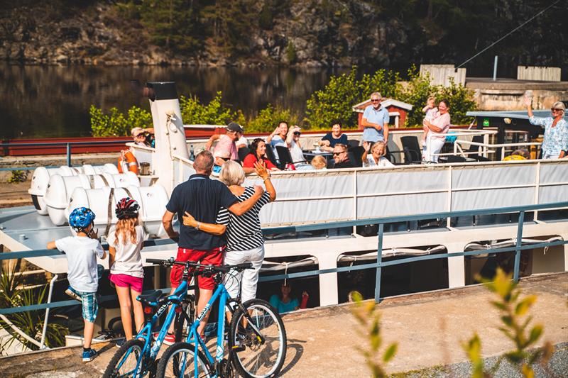 Family waving at passengers on the boat