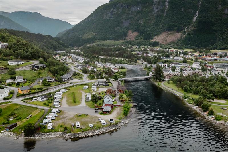 A drone photo of the camping place with the village and mountains in the background.