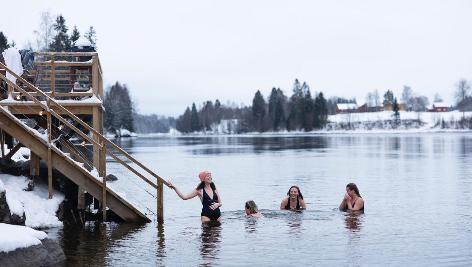 4 women bathing in a river in the winter