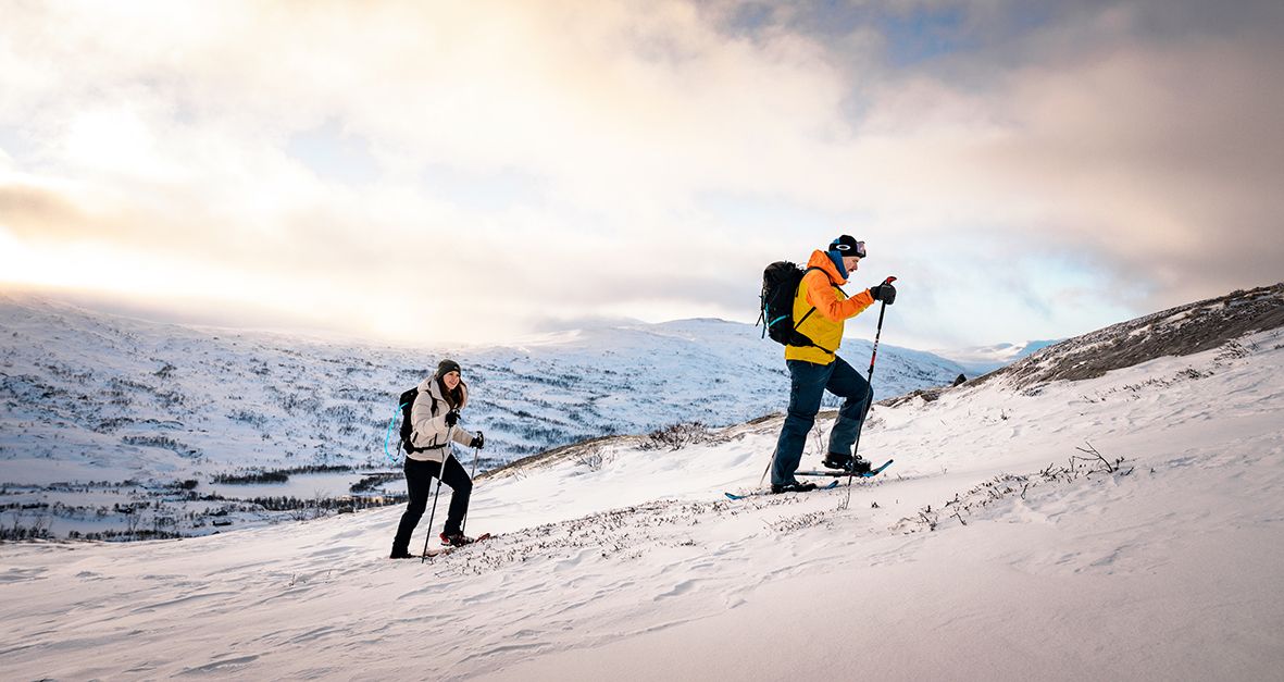 Two people snowshoeing in Hardanger with a stunning winter landscape.