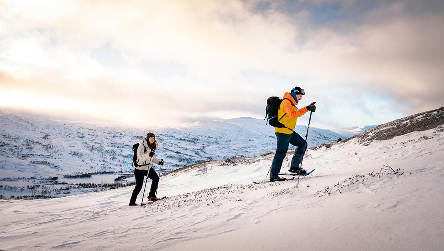 Two people snowshoeing in Hardanger with a stunning winter landscape.