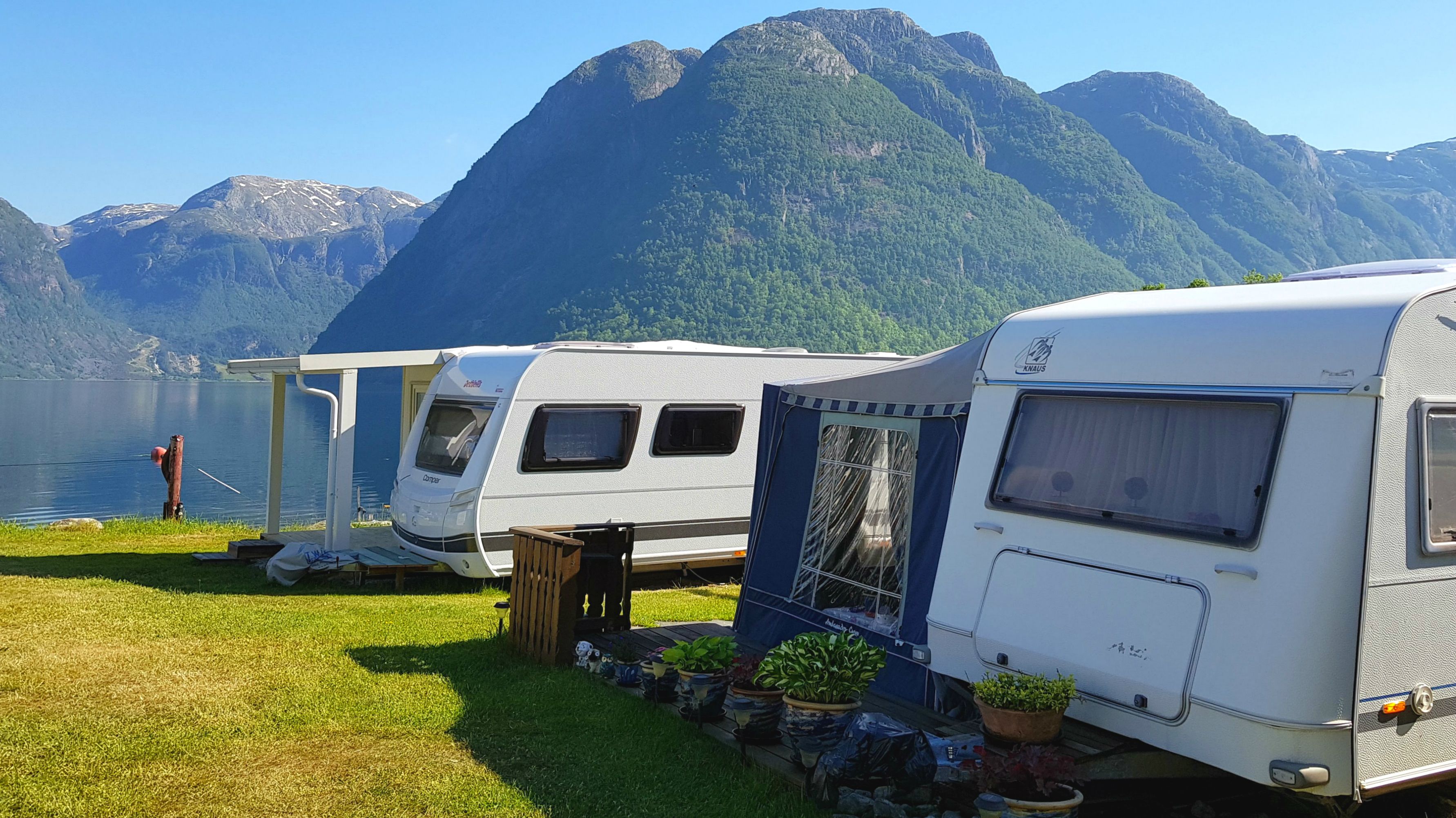 Campingvogner plassert langs fjorden med vakker utsikt mot natur og fjell i Hardanger.