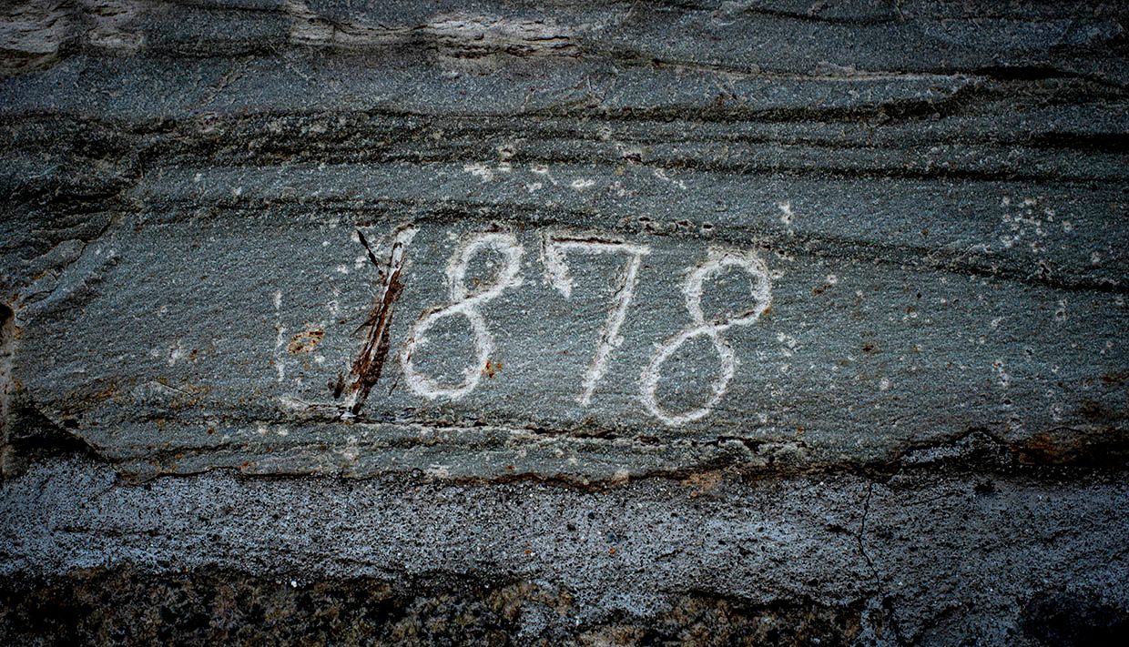 Stone engraved with the year "1878" at Helleland Gard, showcasing its long history.