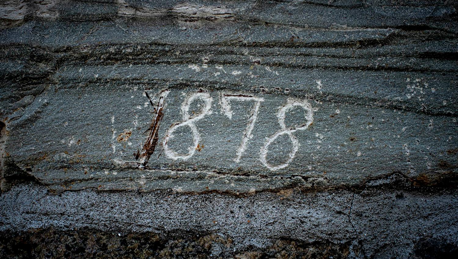 Stone engraved with the year "1878" at Helleland Gard, showcasing its long history.