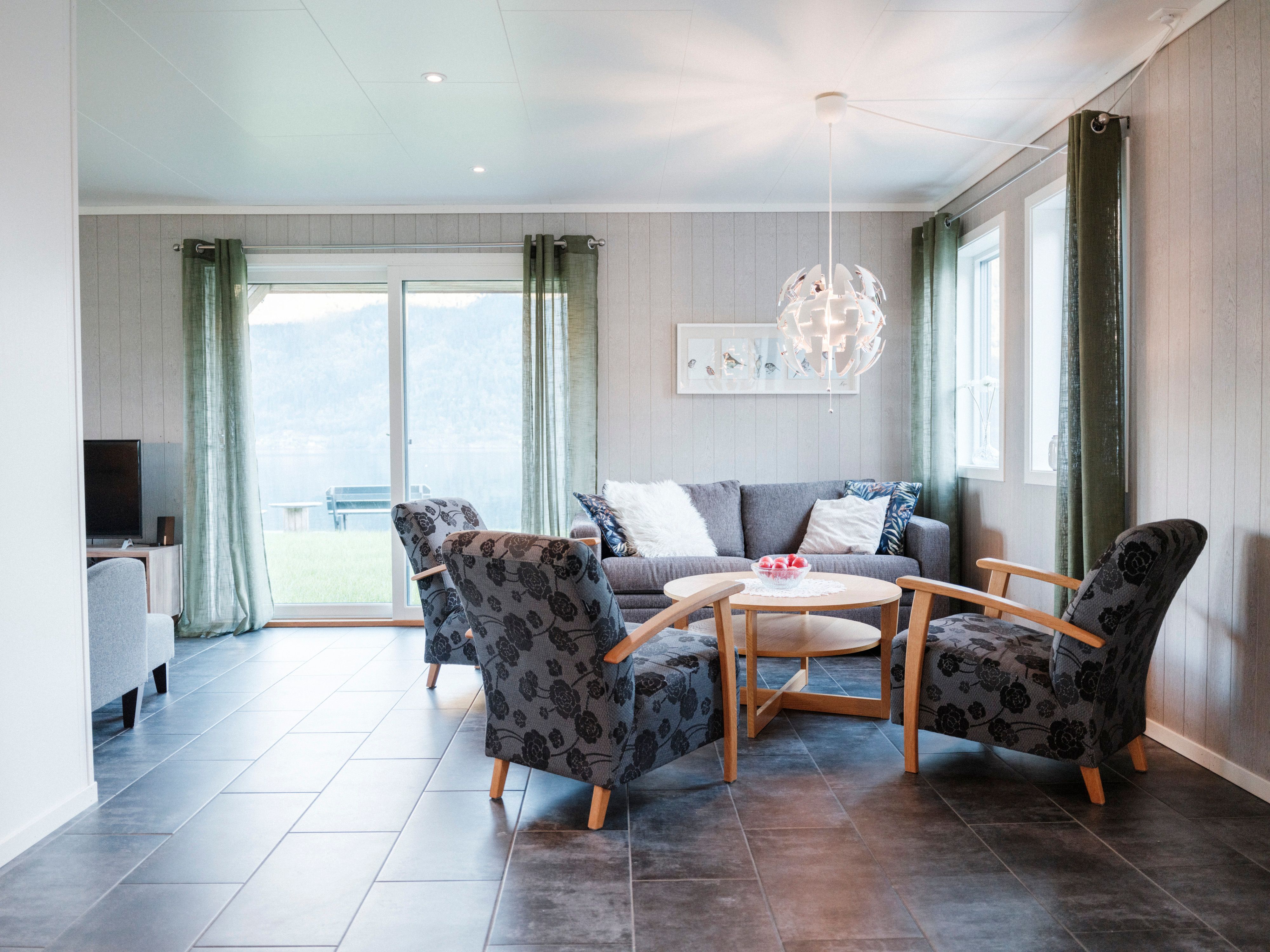 Bright living room at Aga Fjordapartments with modern furniture and fjord view in Hardanger.