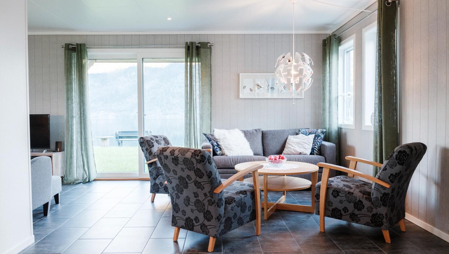 Bright living room at Aga Fjordapartments with modern furniture and fjord view in Hardanger.