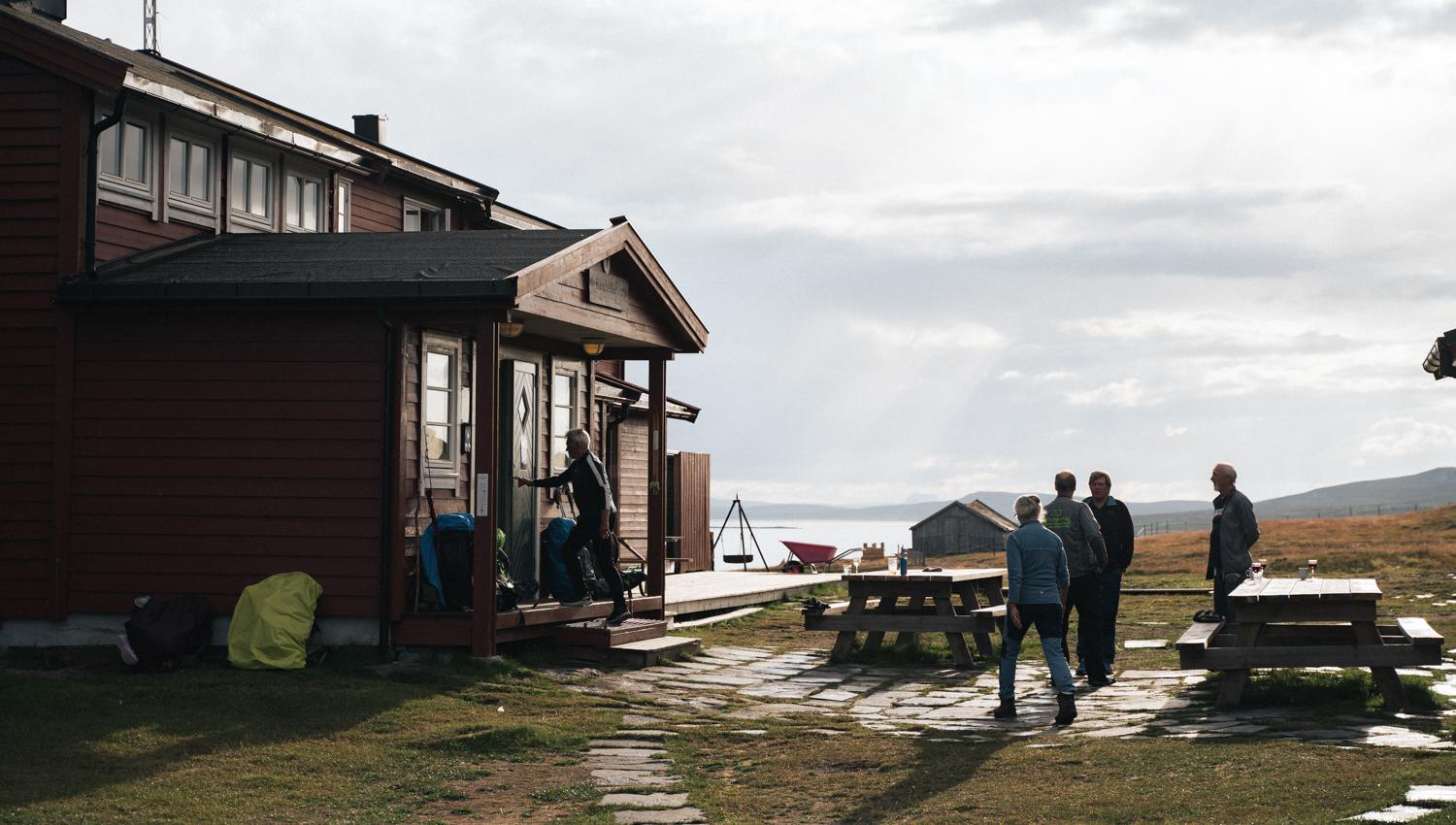 Some people are standing by the entrance to the mountain lodge.
