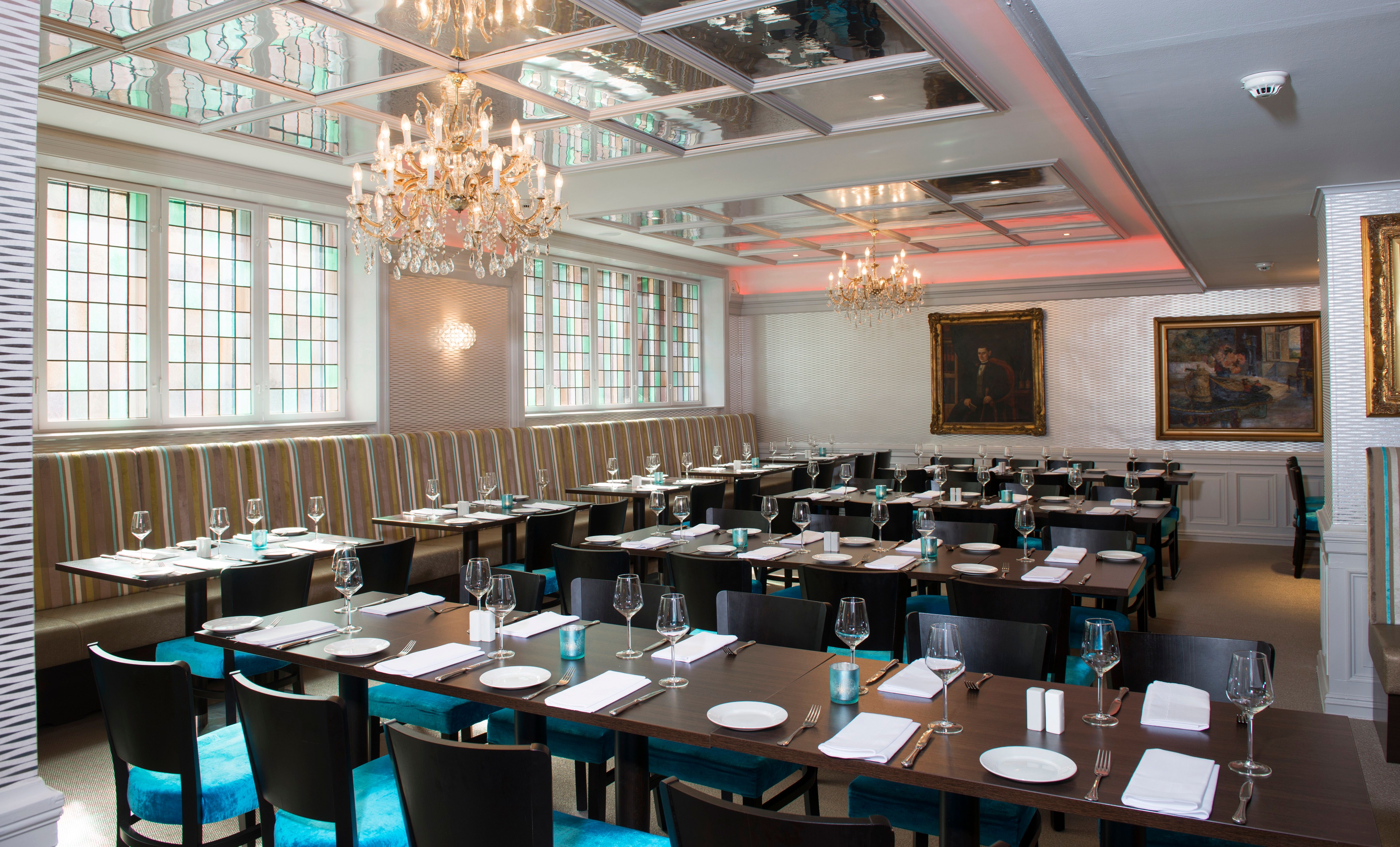 Dining room with turquoise chairs, wooden tables and large windows. Thon Hotel Slottsparken, Oslo. Photo