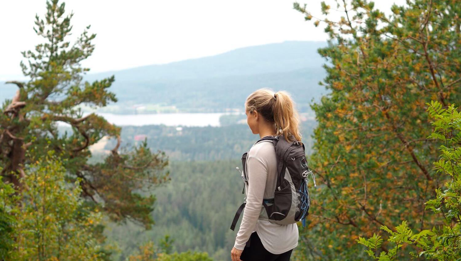 woman in the woods with a backpack on her back