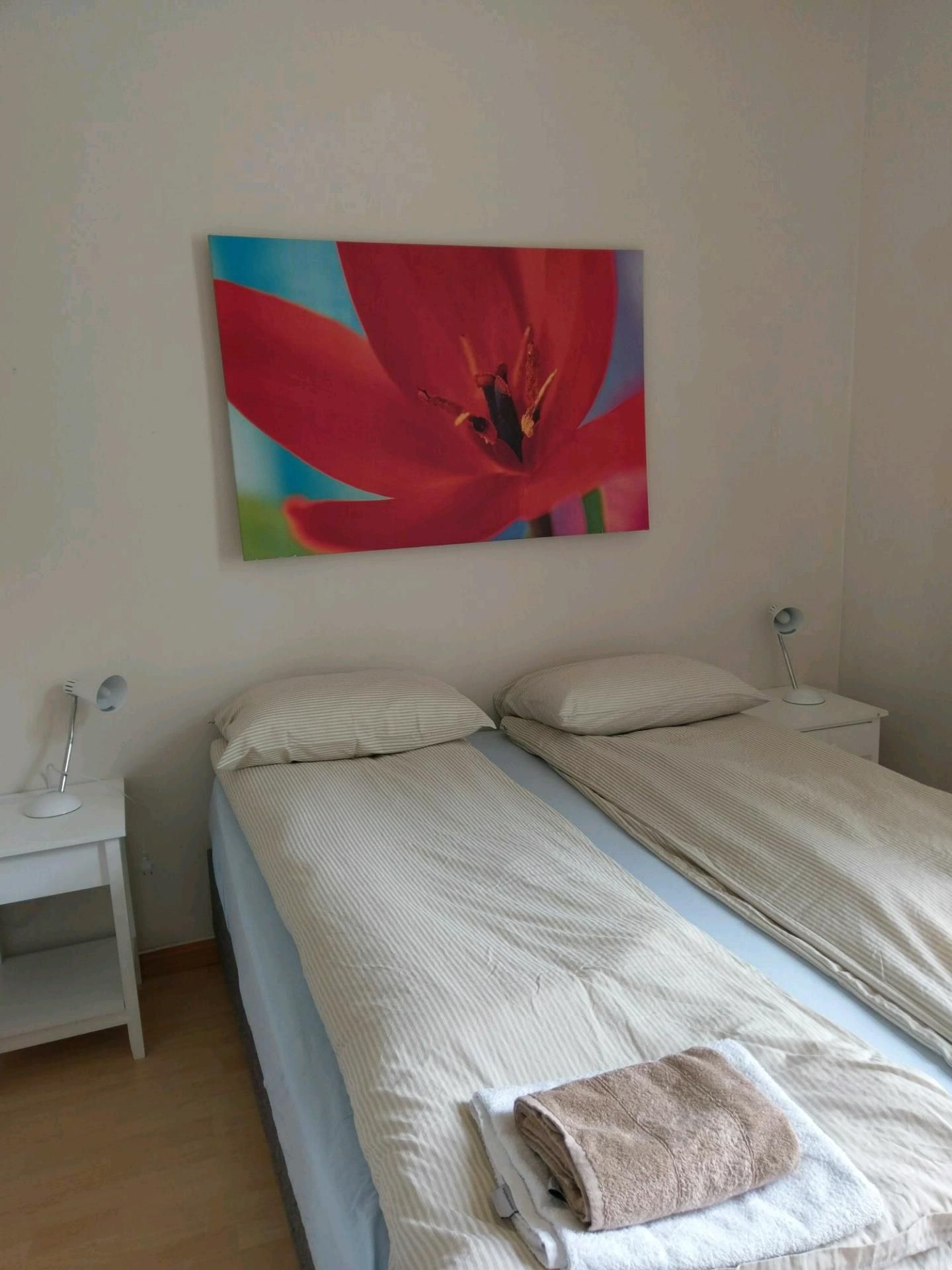Bright and comfortable bedroom at Vikinghaug Apartments with two single beds and modern wall art.