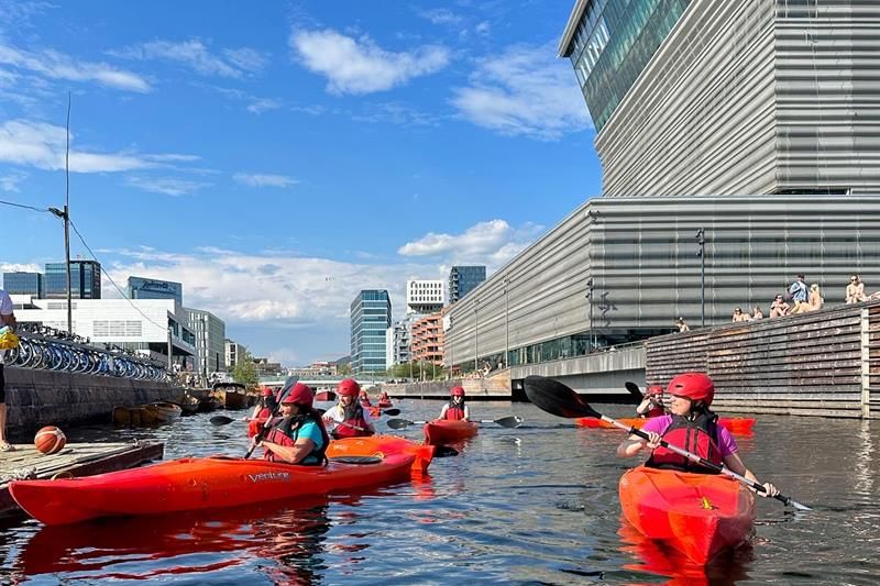 A group paddling in front of the Opera House