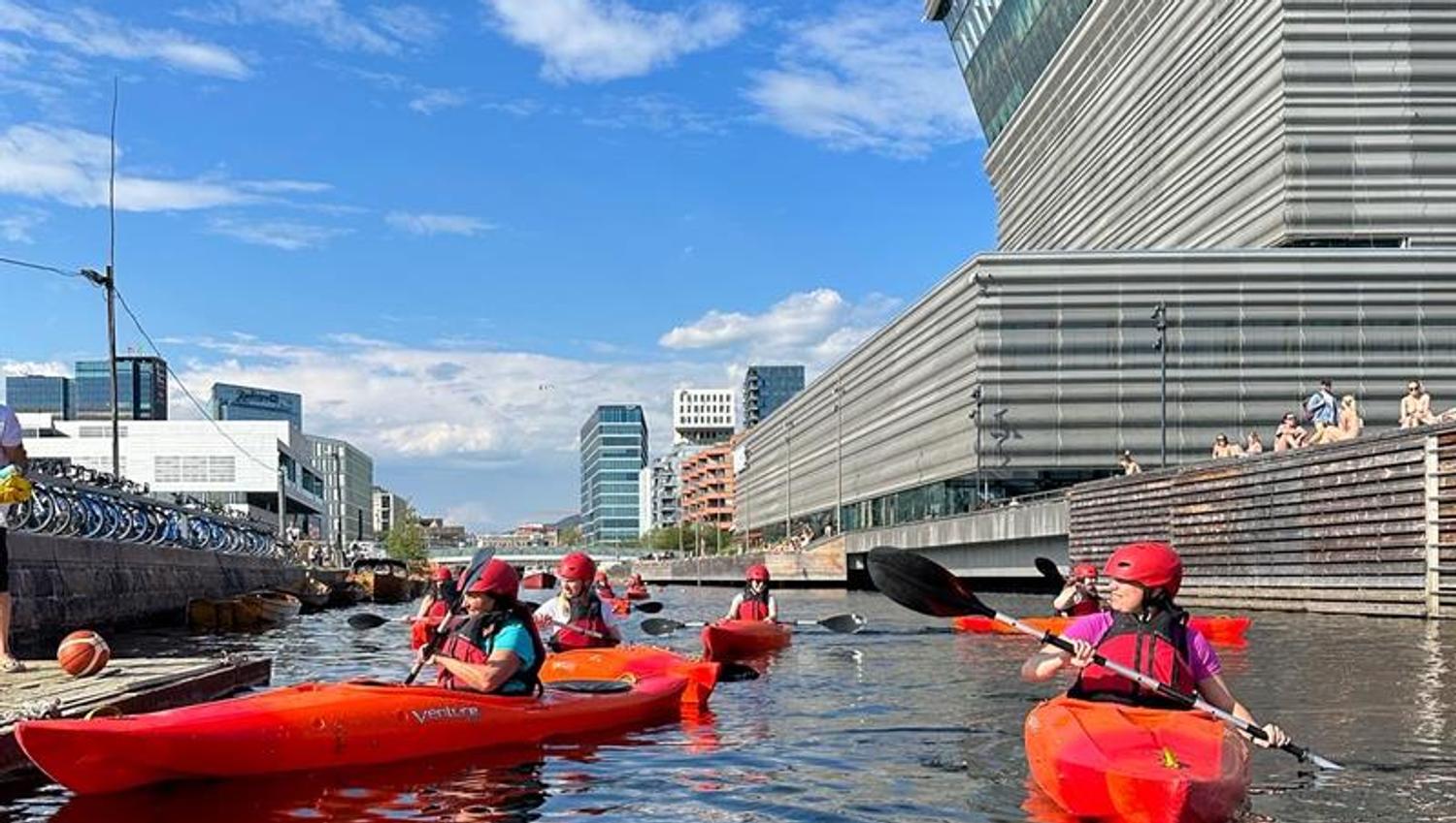 A group paddling in front of the Opera House