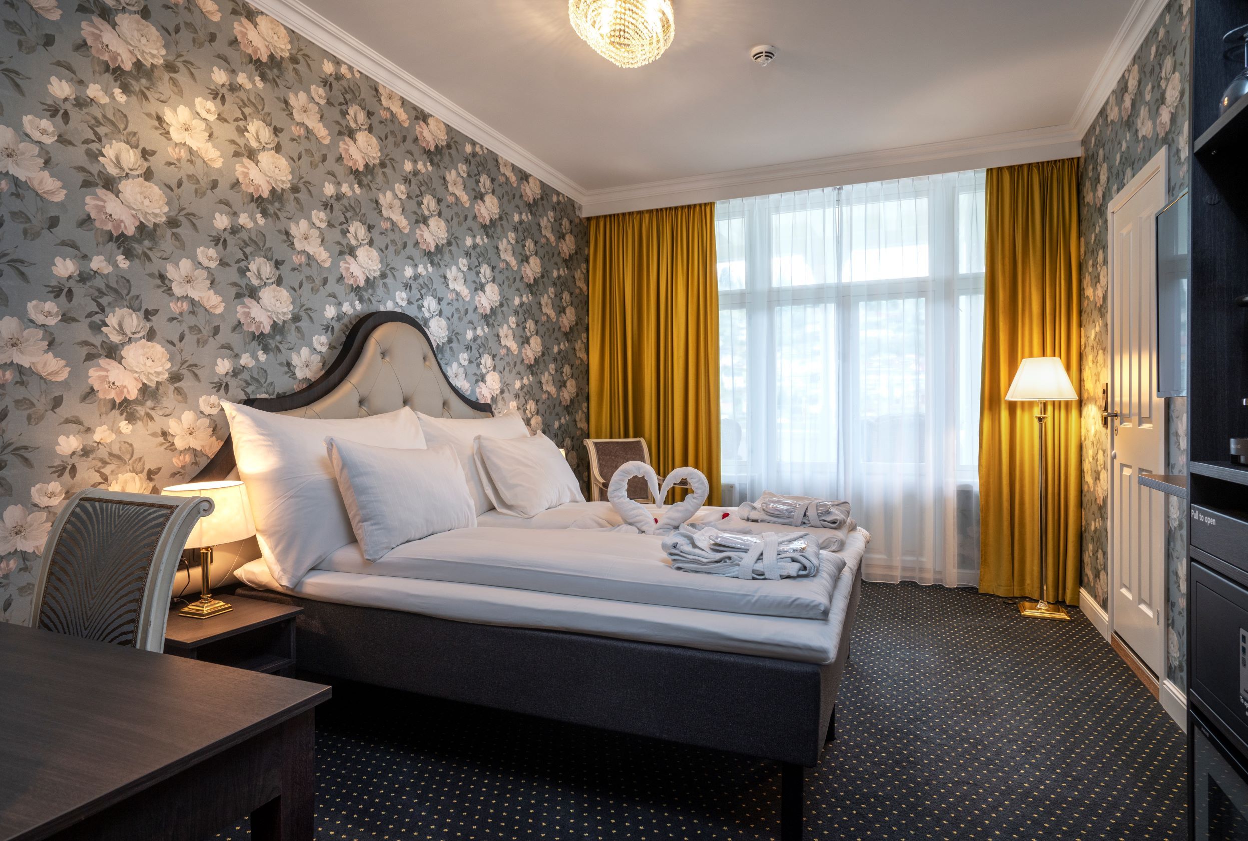 Elegant hotel room at Thon Hotel Sandven, featuring classic decor and a romantic ambiance.