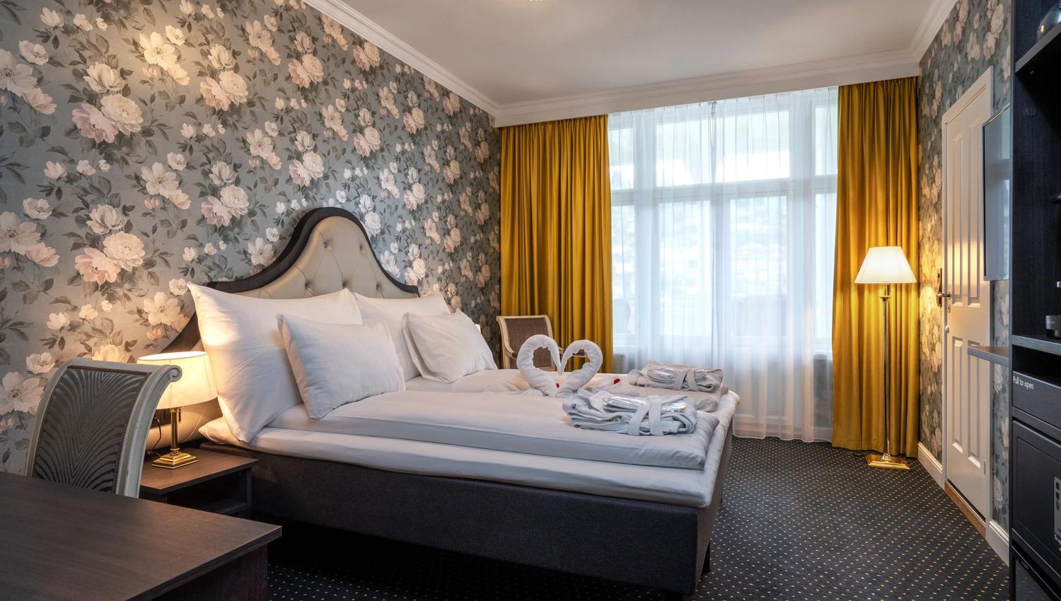 Elegant hotel room at Thon Hotel Sandven, featuring classic decor and a romantic ambiance.