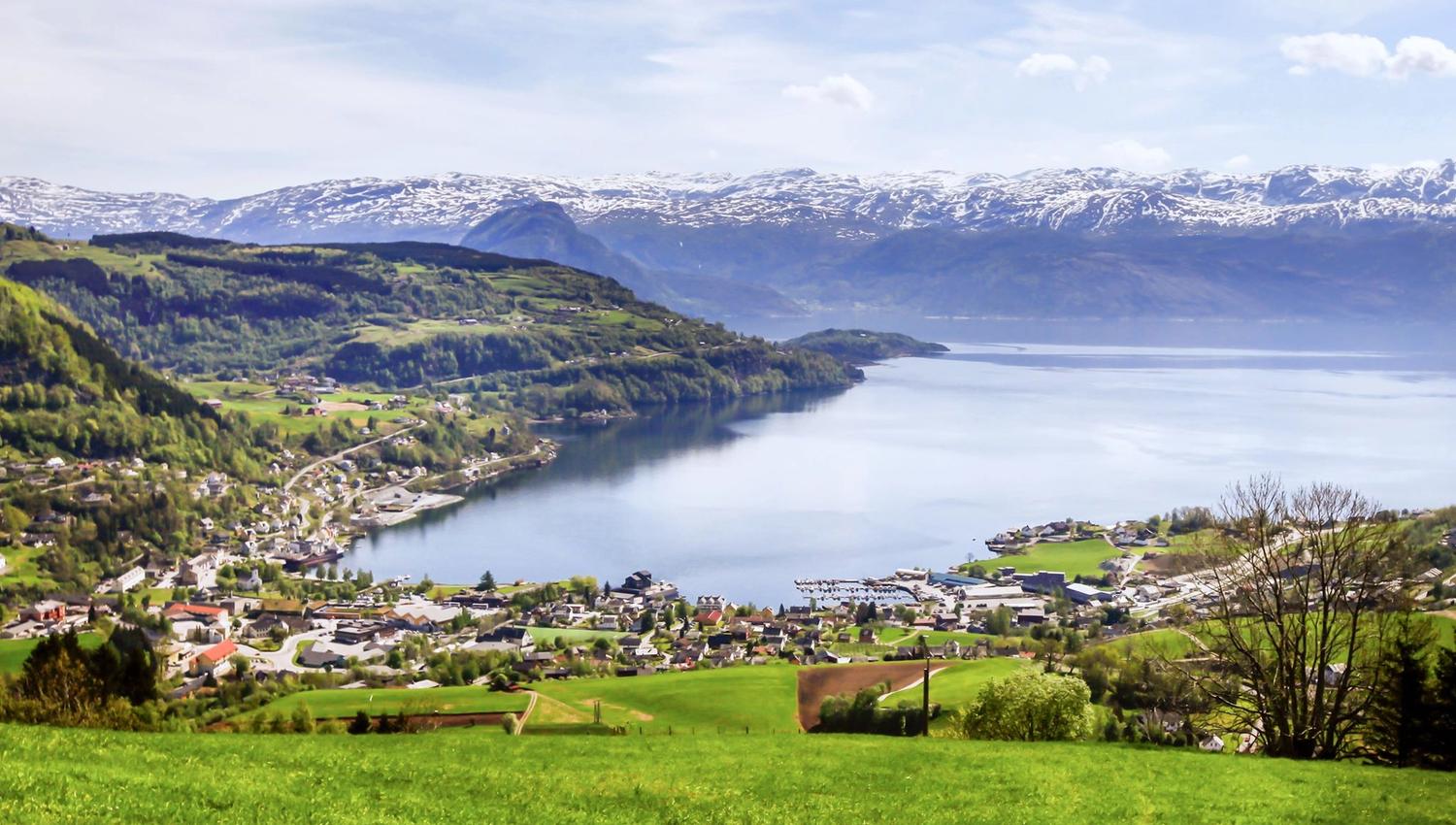 Panoramic view of the Hardangerfjord and the snow-capped mountains surrounding the fjord.
