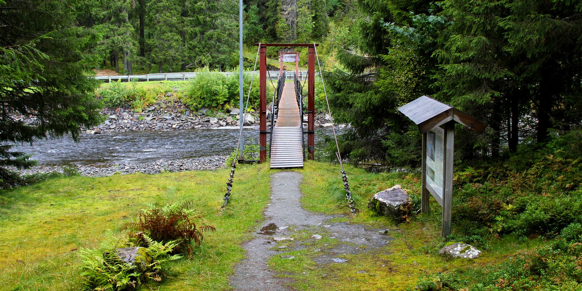 Bridge crossing the river to an information board