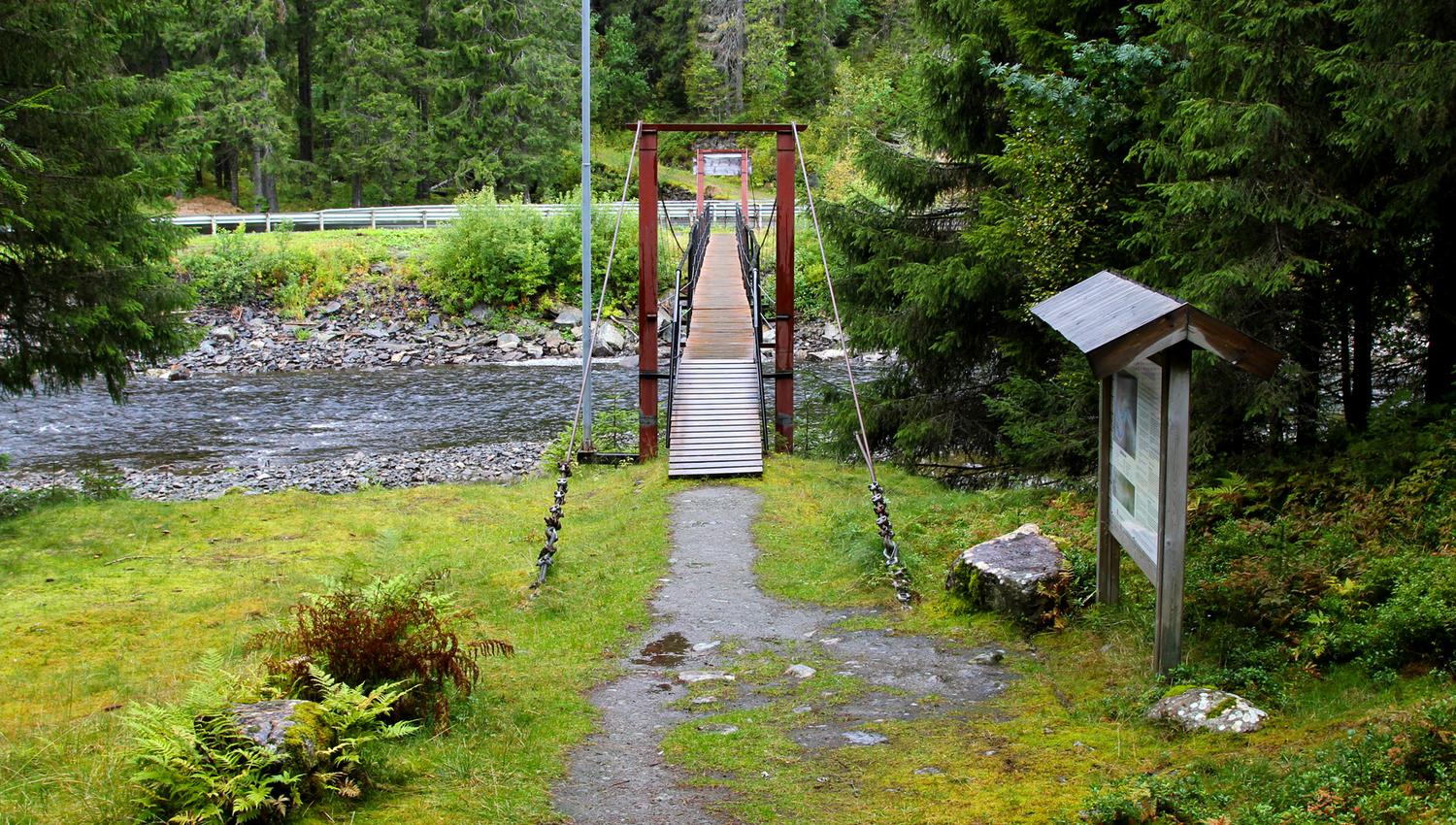 Bridge crossing the river to an information board
